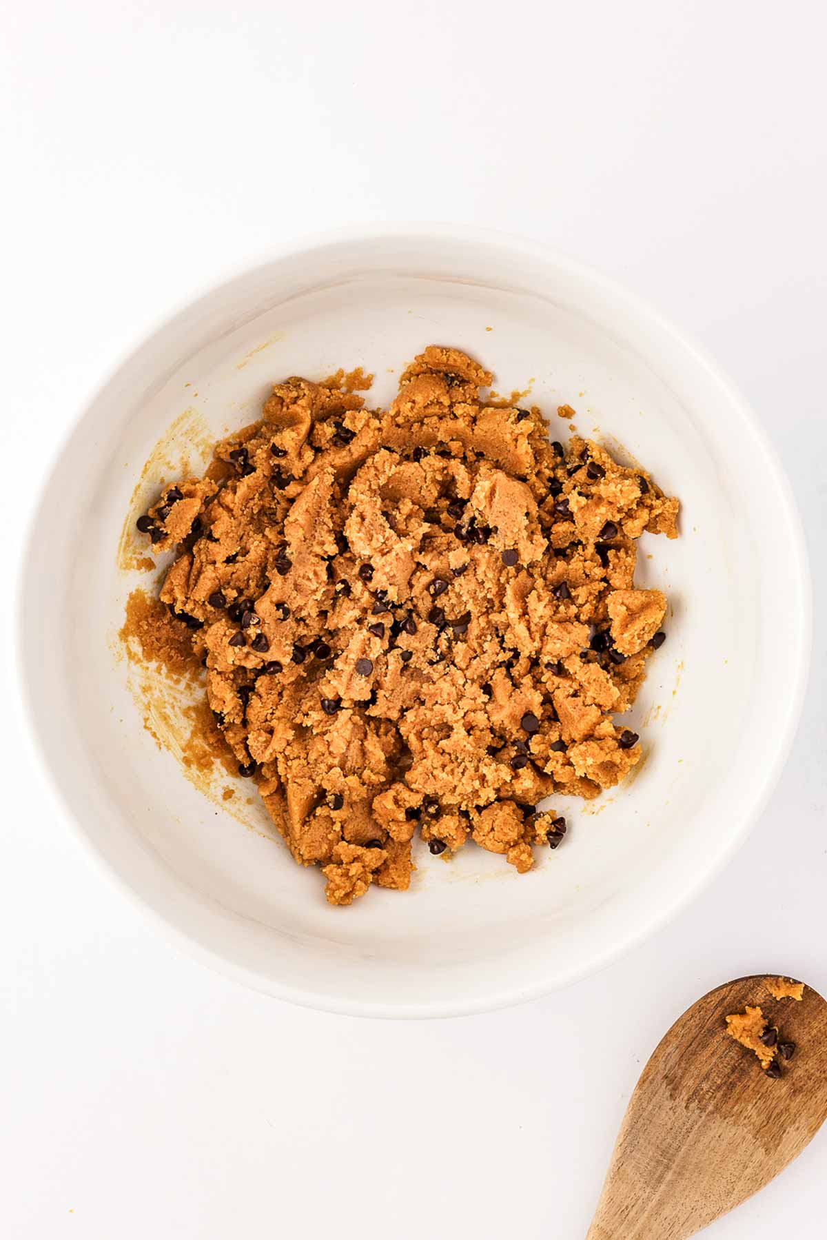 overhead view of chocolate chip peanut butter cookie dough in white bowl