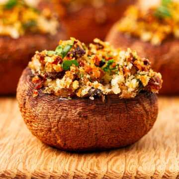 frontal view of stuffed mushroom on wooden chopping board