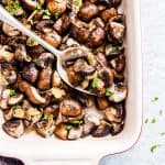 Garlic Butter Mushrooms in a Le Creuset casserole dish with a spoon.