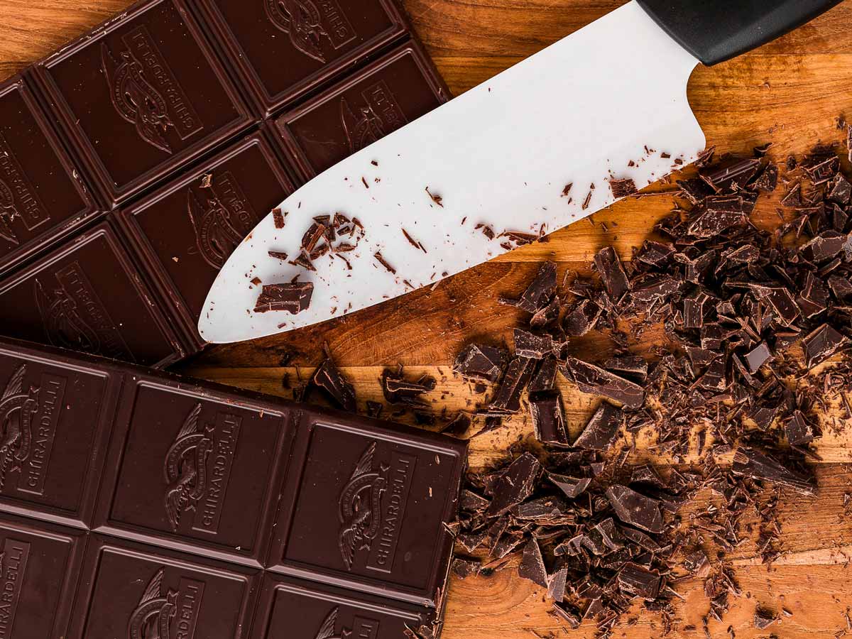 overhead view of chopped chocolate on wooden board