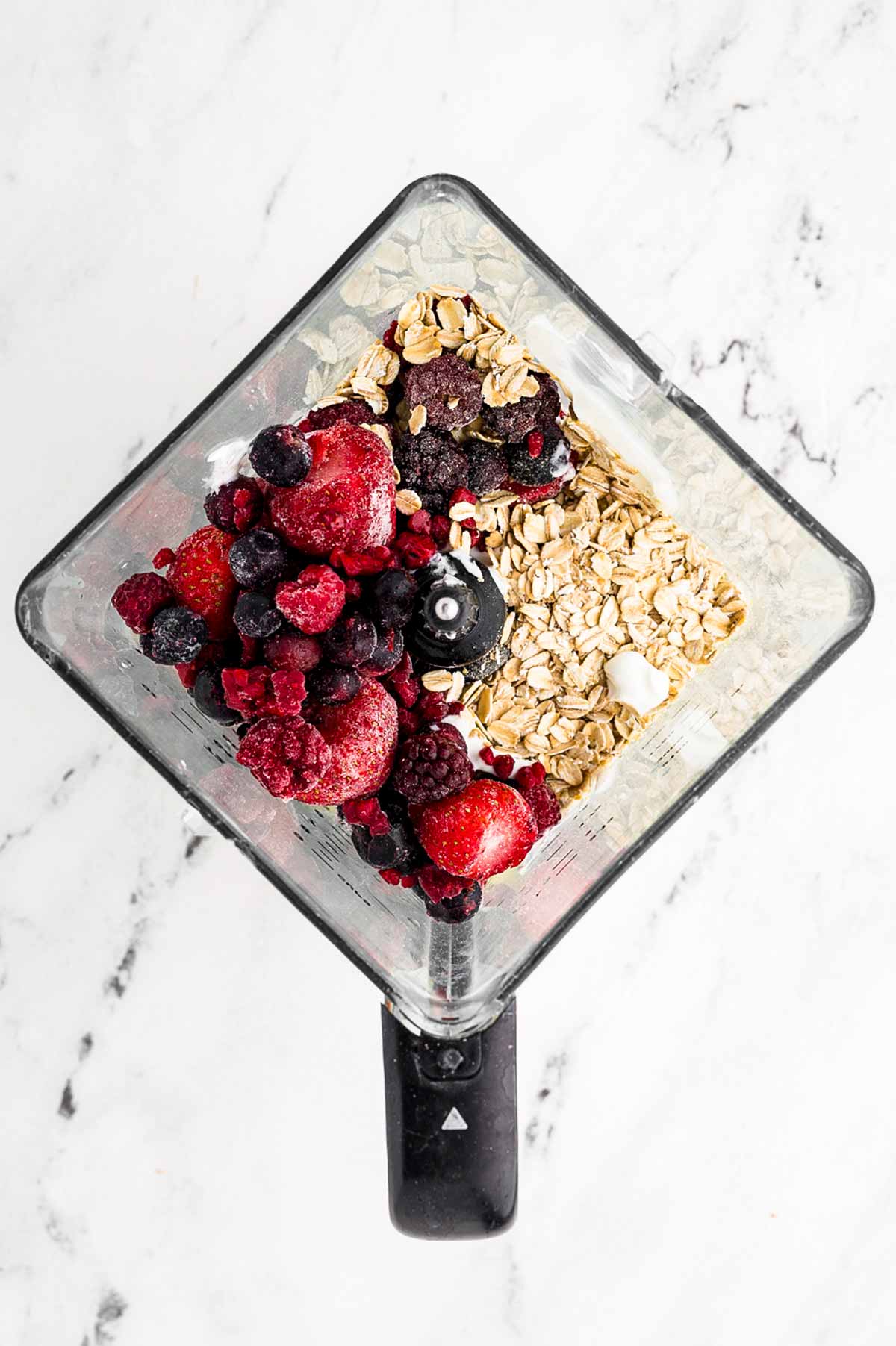 overhead view of berries and oats in blender cup