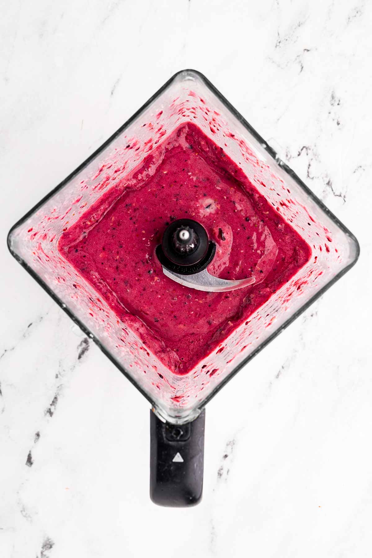 overhead view of mixed berry smoothie in blender cup