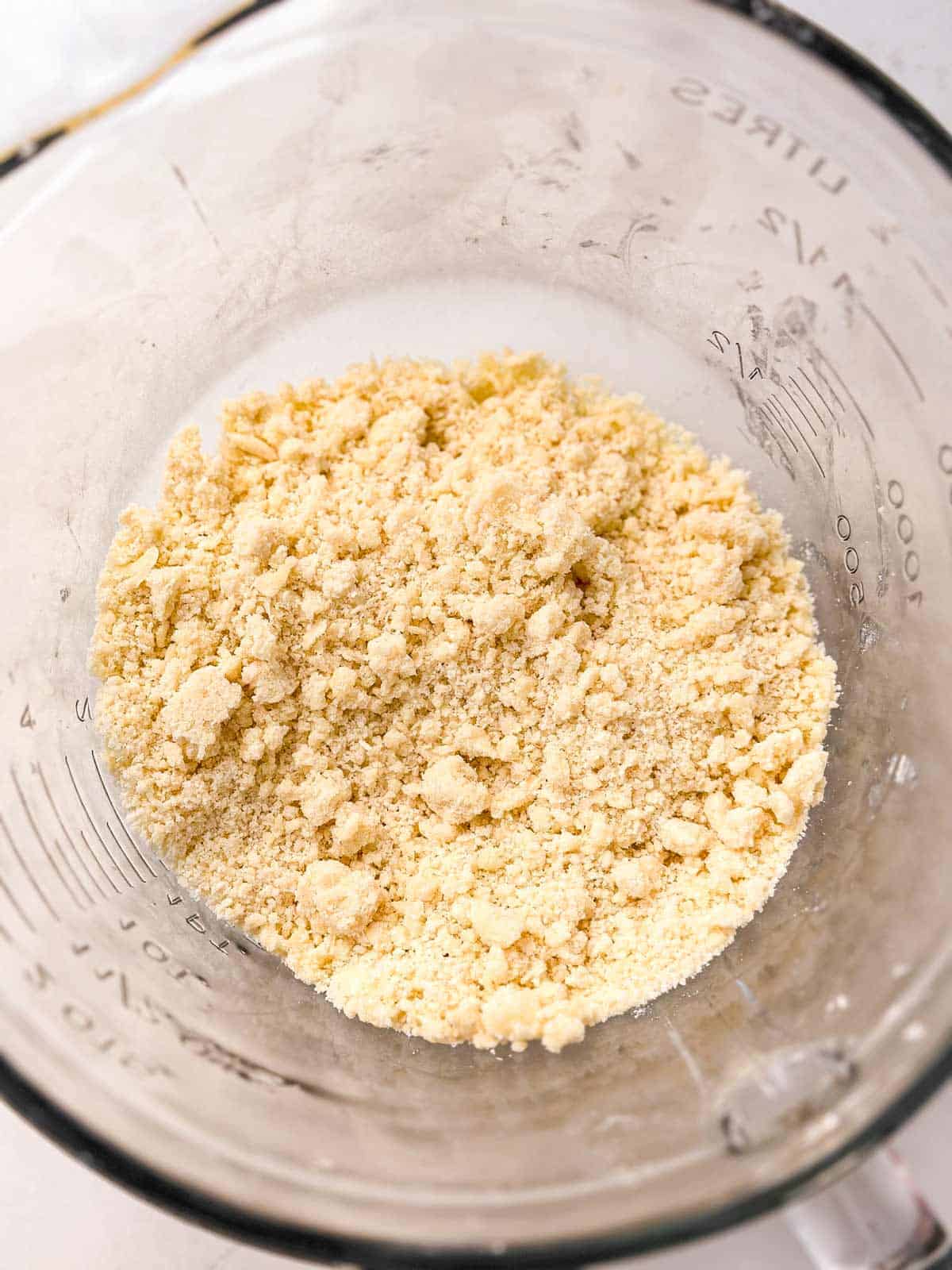 overhead view of flour with butter cut in in glass bowl