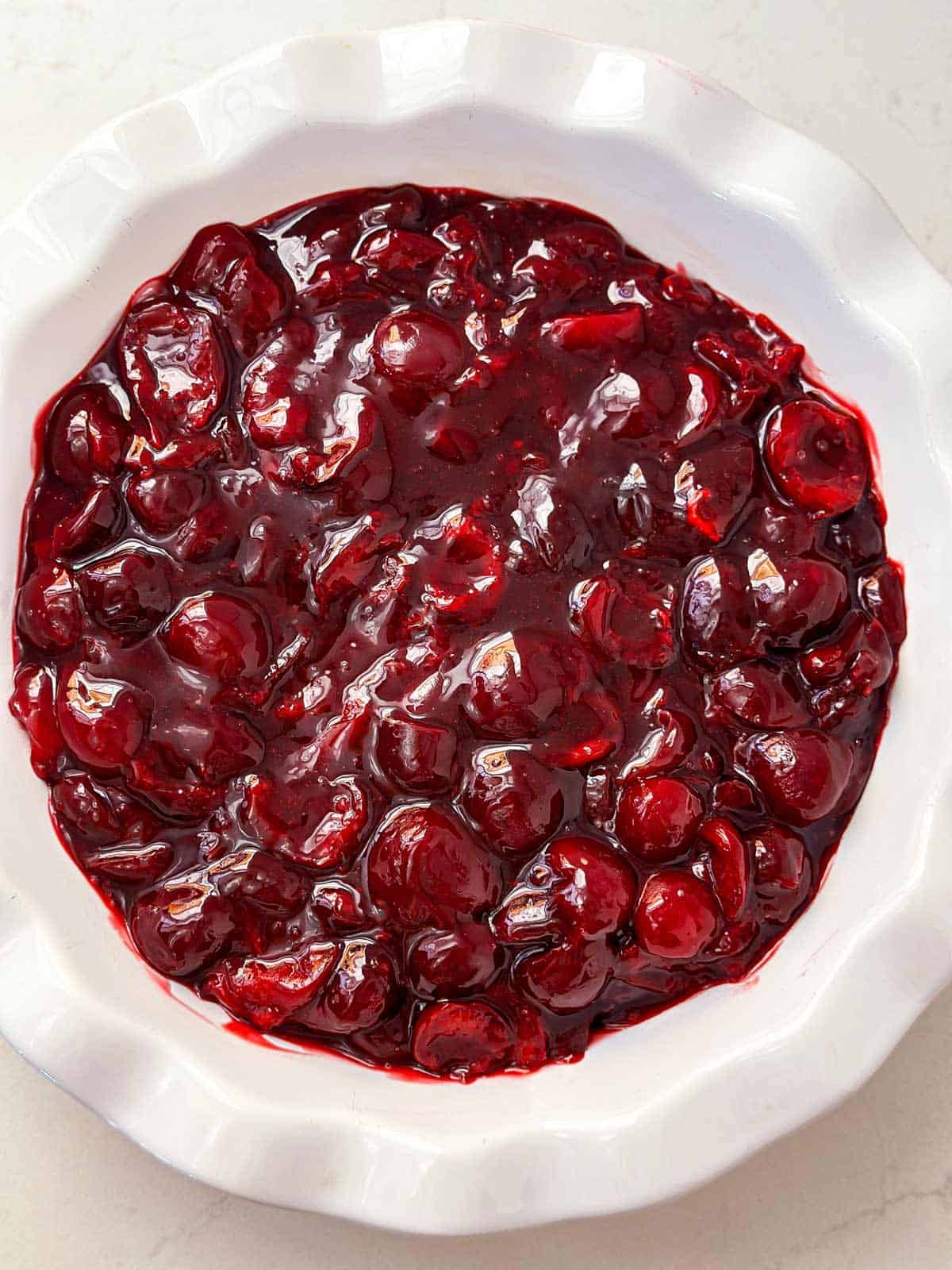 overhead view of cherry filling in fluted pie dish