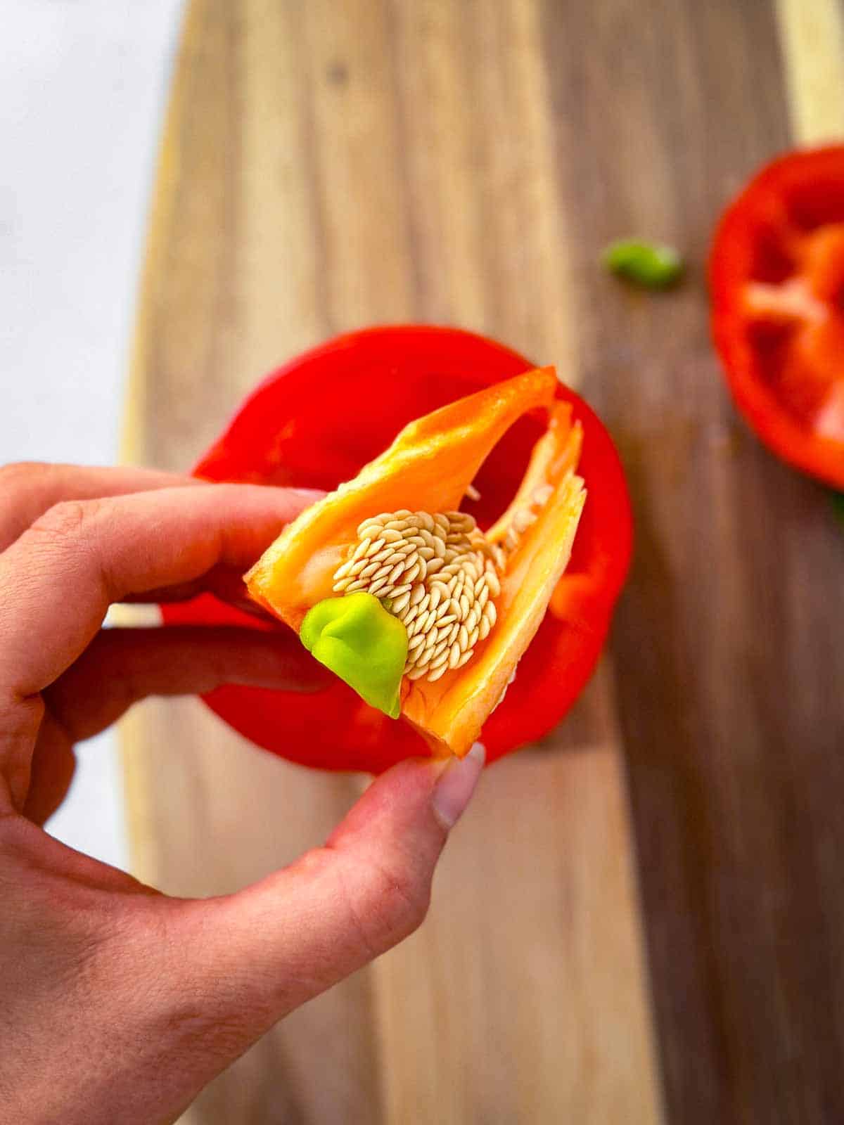 female hand holding seeds from bell pepper