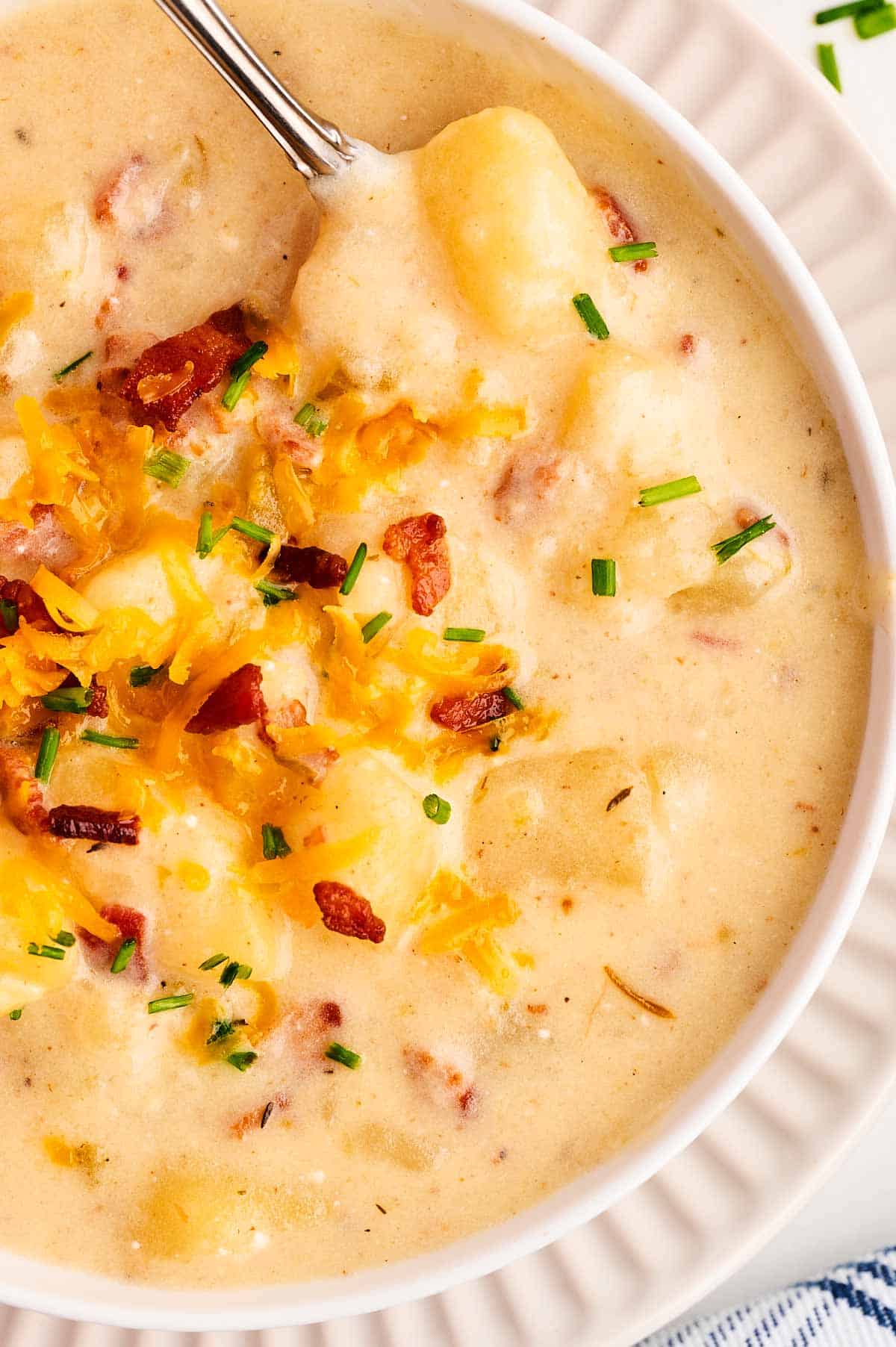 overhead close up view of white bowl filled with potato soup