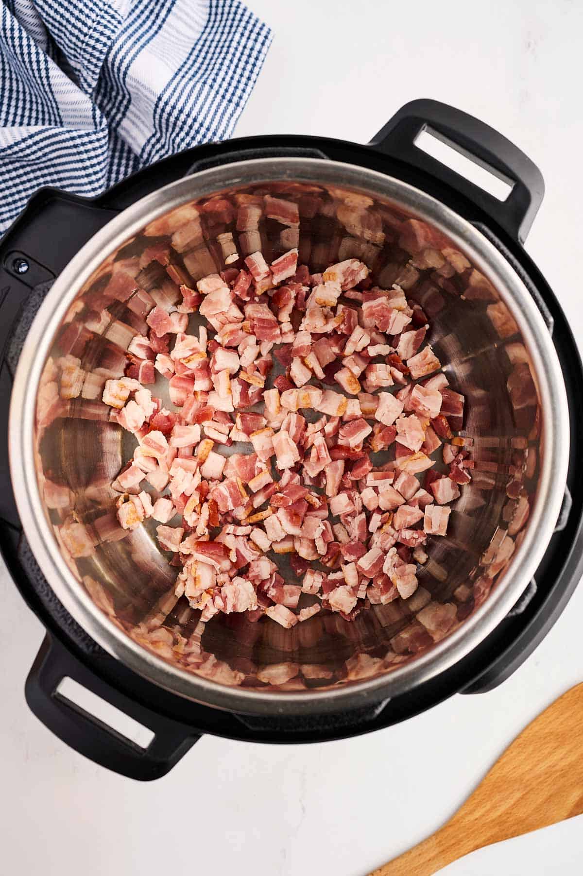 overhead view of uncooked chopped bacon in instant pot