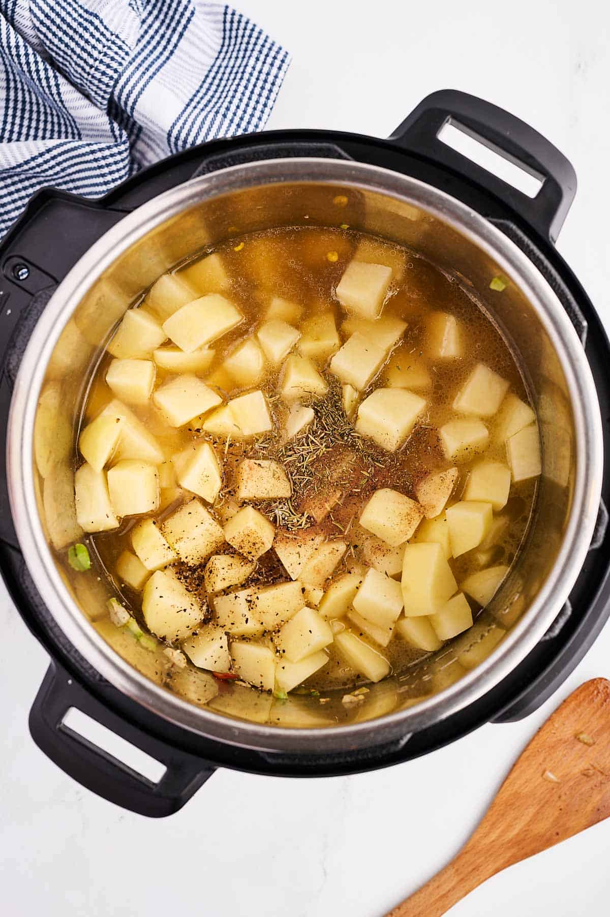 overhead view of potatoes and broth in instant pot