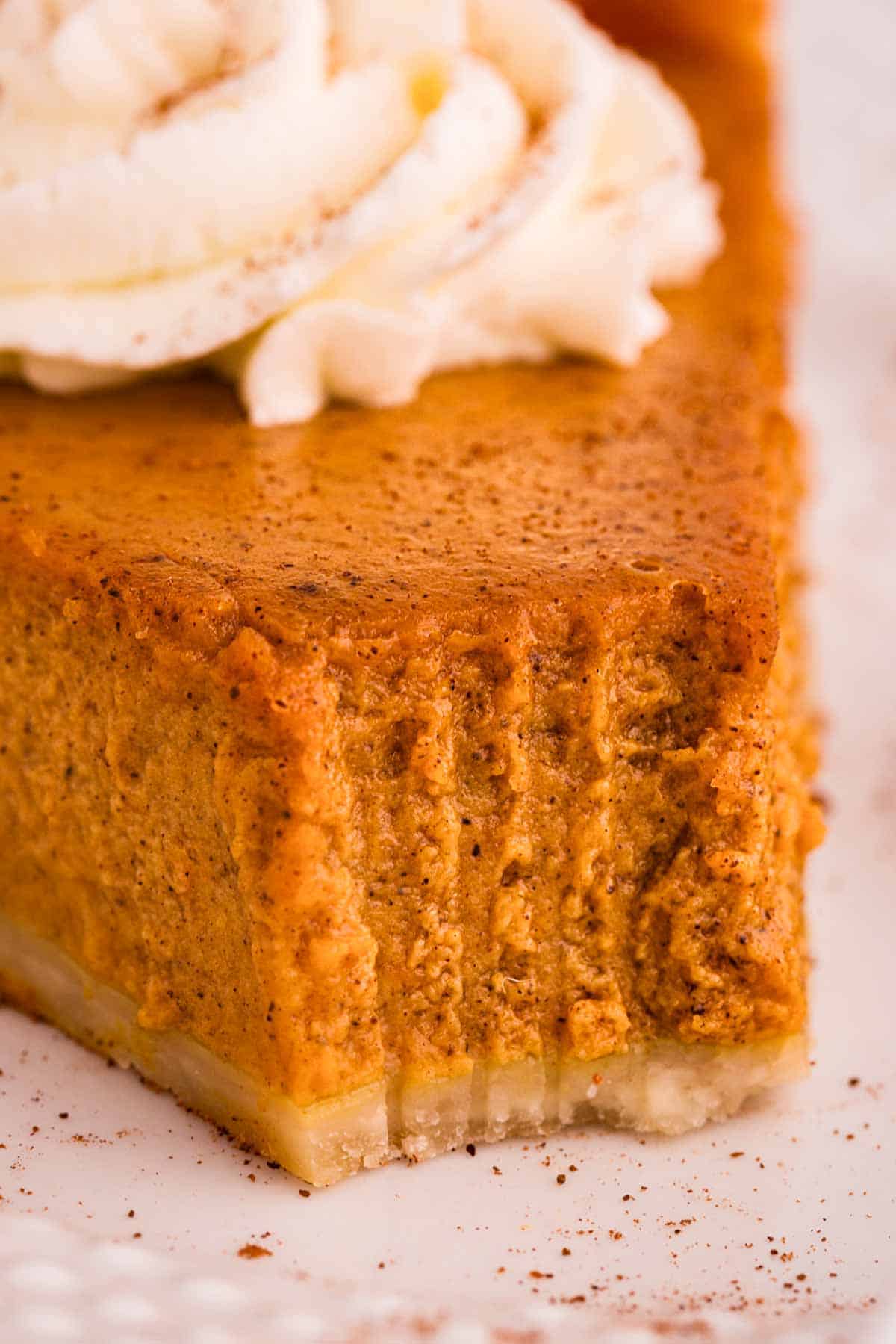 close up photo of pumpkin pie slice with bite taken out