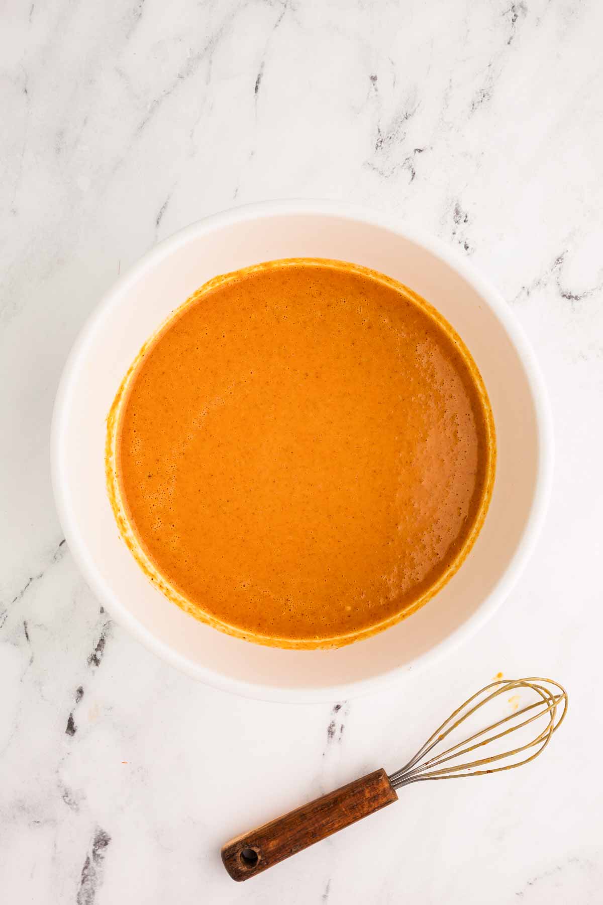 overhead view of pumpkin pie filling in white bowl