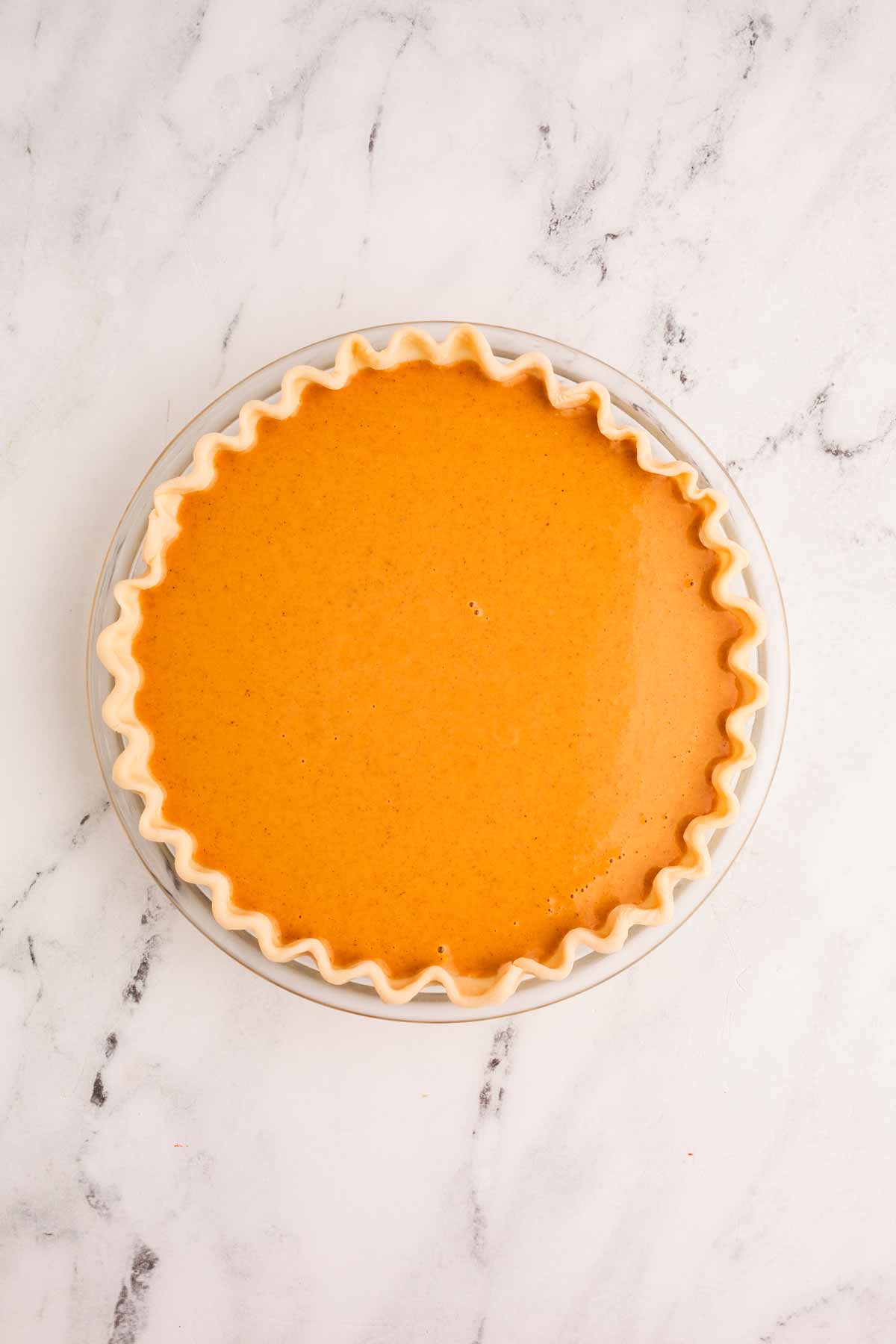 overhead view of unbaked pumpkin pie