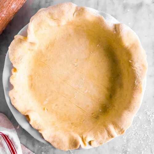 overhead view of pie crust fit into white pie dish