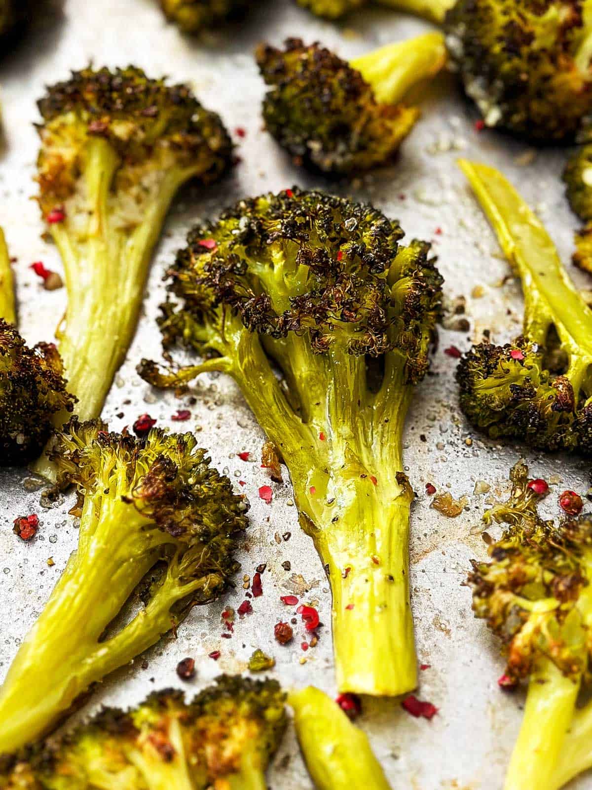 close up photo of roasted broccoli on sheet pan