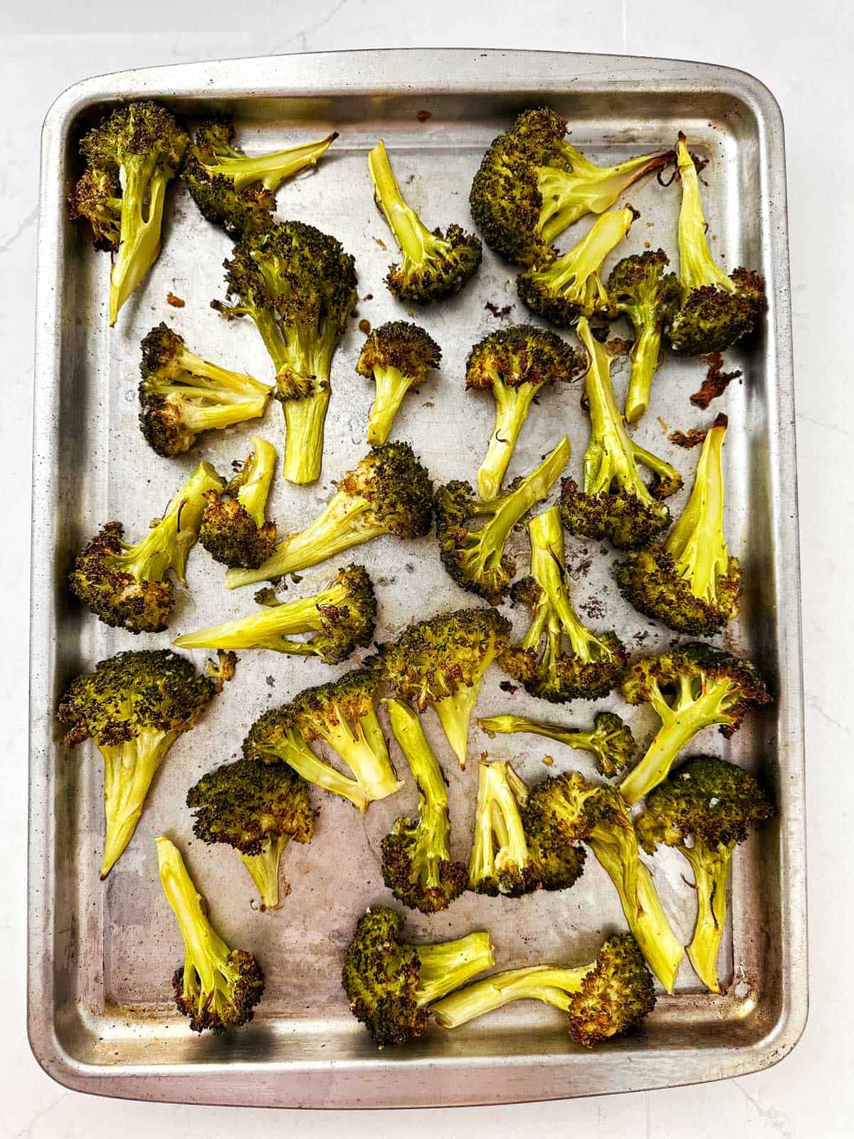 overhead view of sheet pan filled with roasted broccoli florets