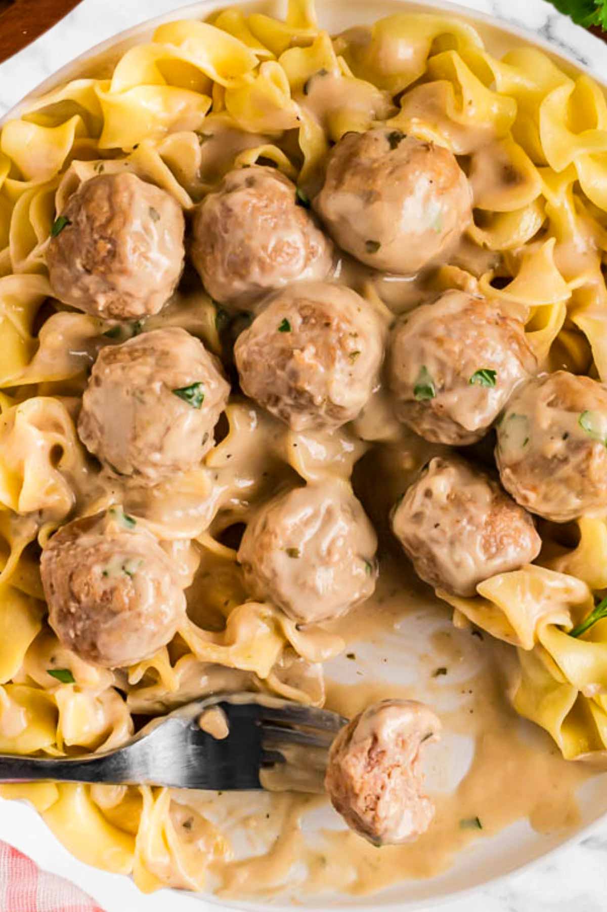 overhead view of swedish meatballs and noodles with fork