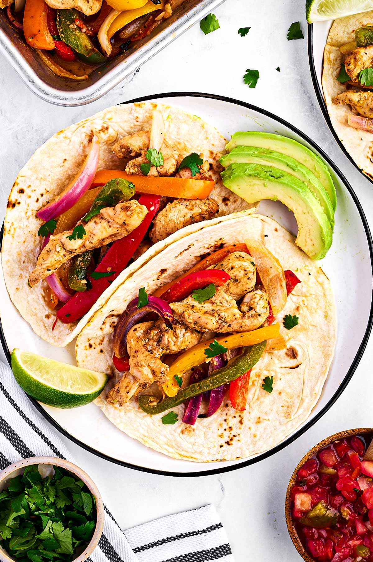 overhead view of chicken fajitas on white plate