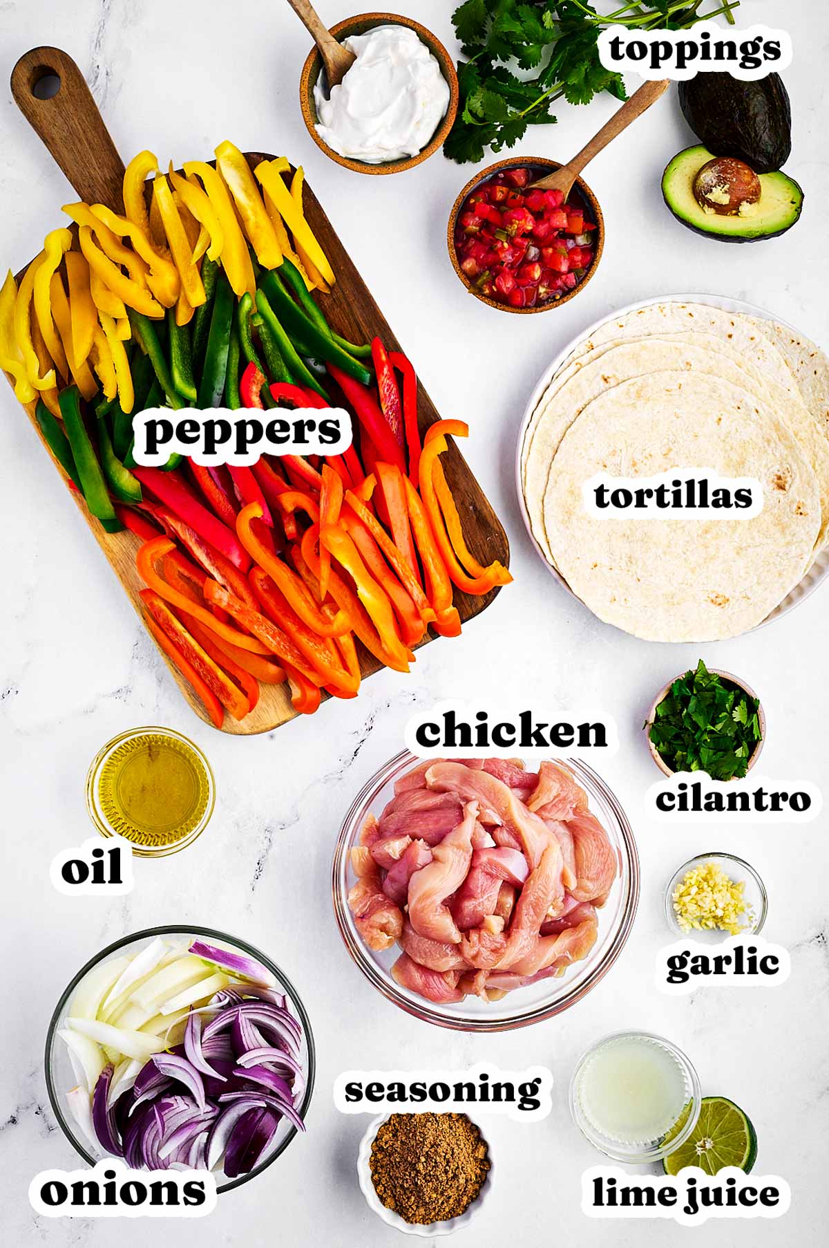 overhead view of ingredients to make sheet pan chicken fajitas with text labels