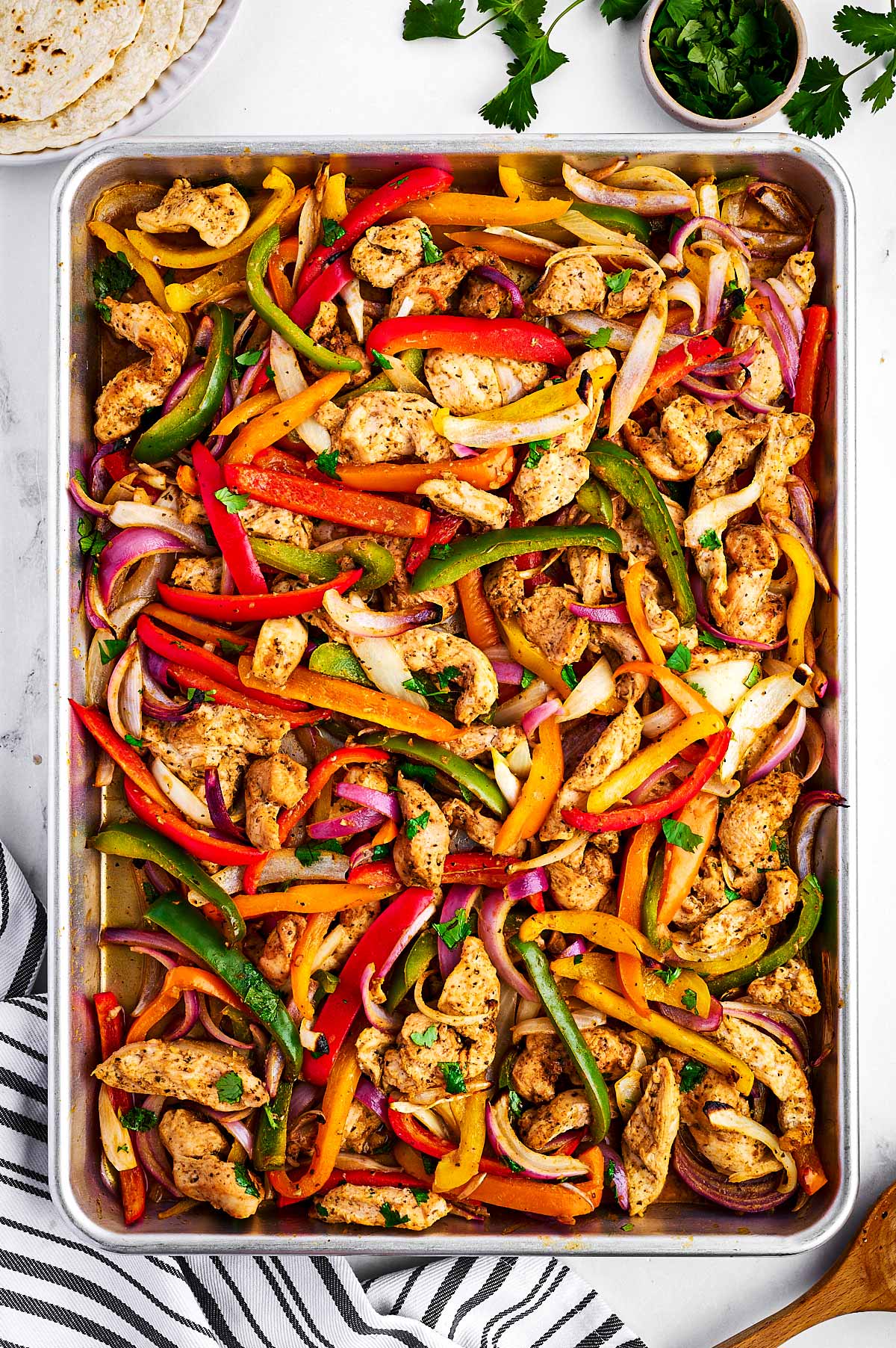 overhead view of baked chicken fajita mixture on sheet pan