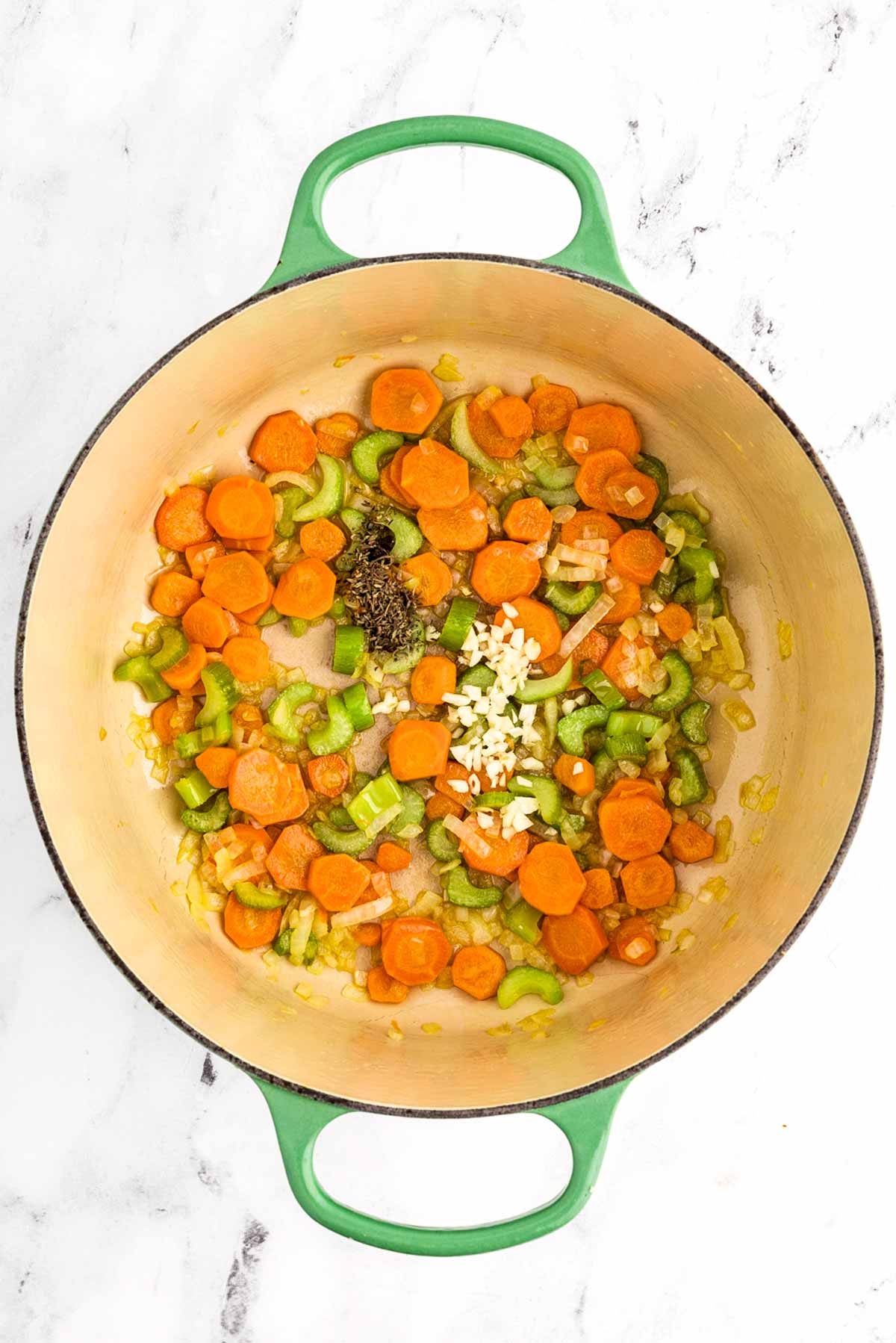 butter melting in a dutch oven with sautéing vegetables