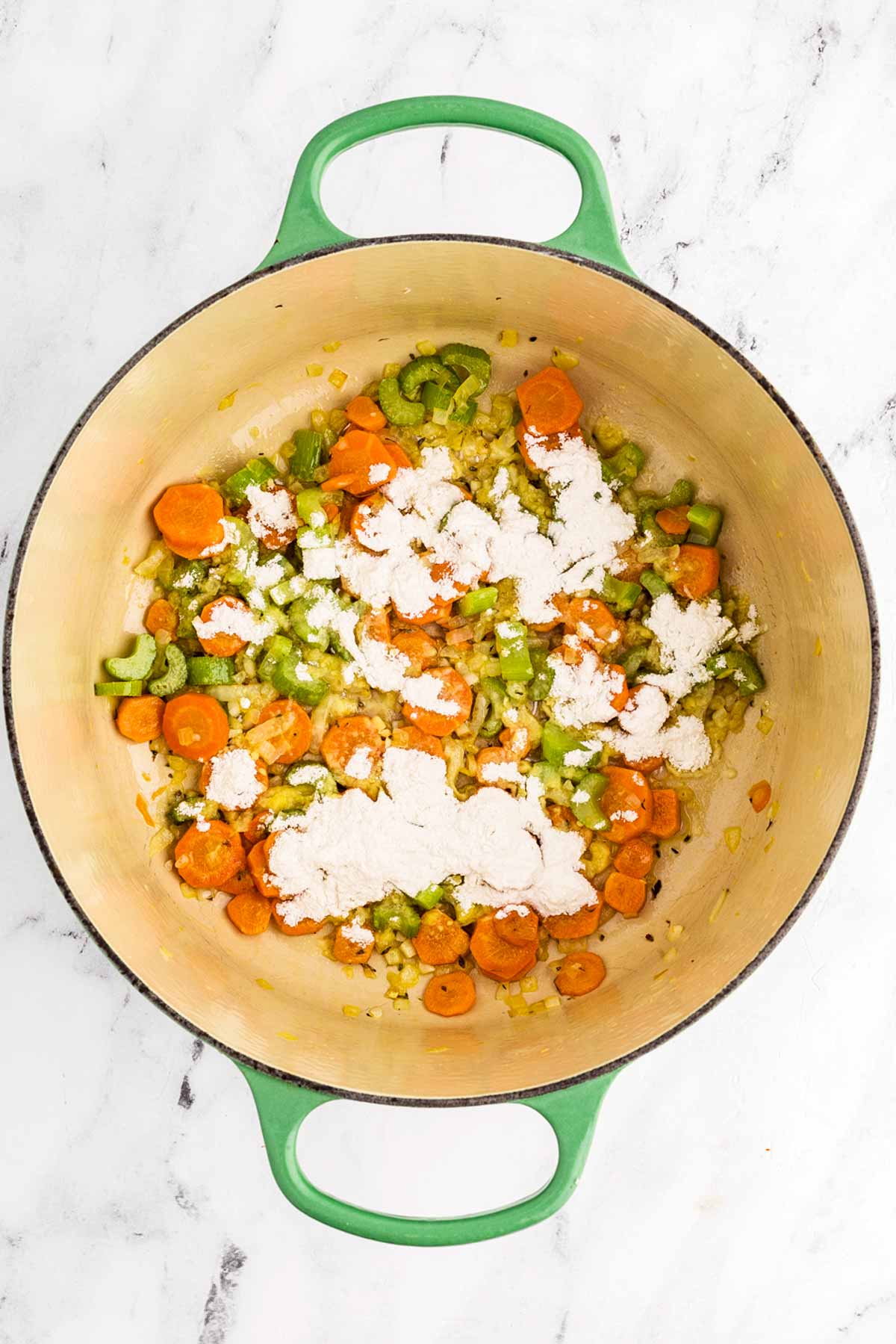 flour sprinkled over vegetables in the dutch oven