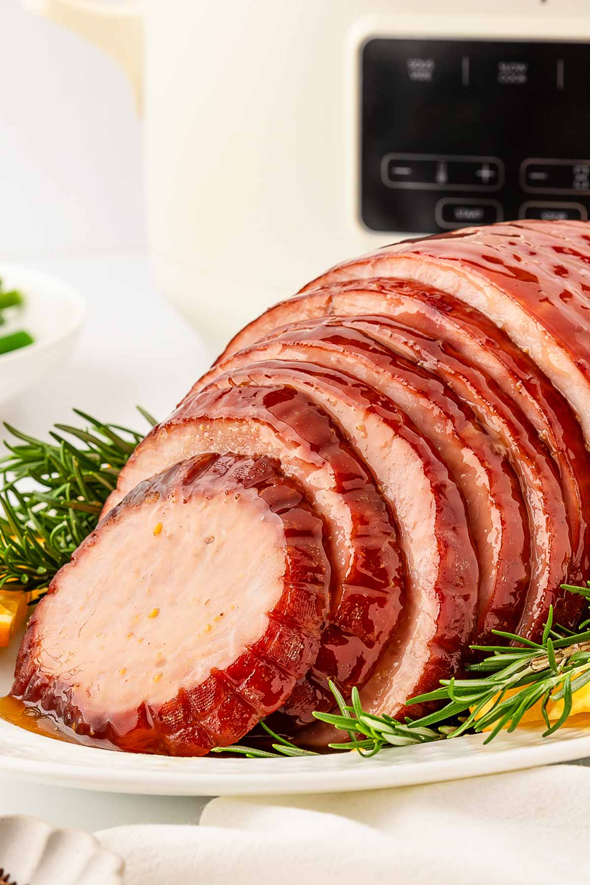 frontal view of sliced ham in front of slow cooker