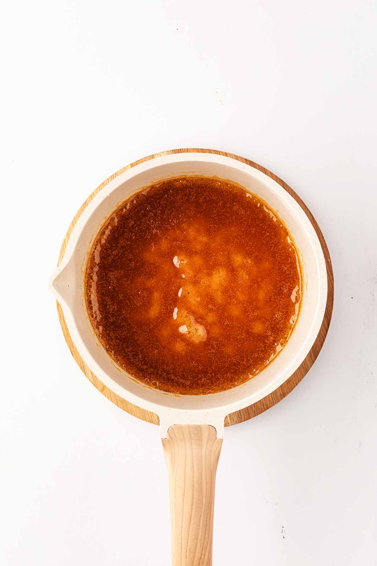 overhead view of thickened ham glaze in small white saucepan