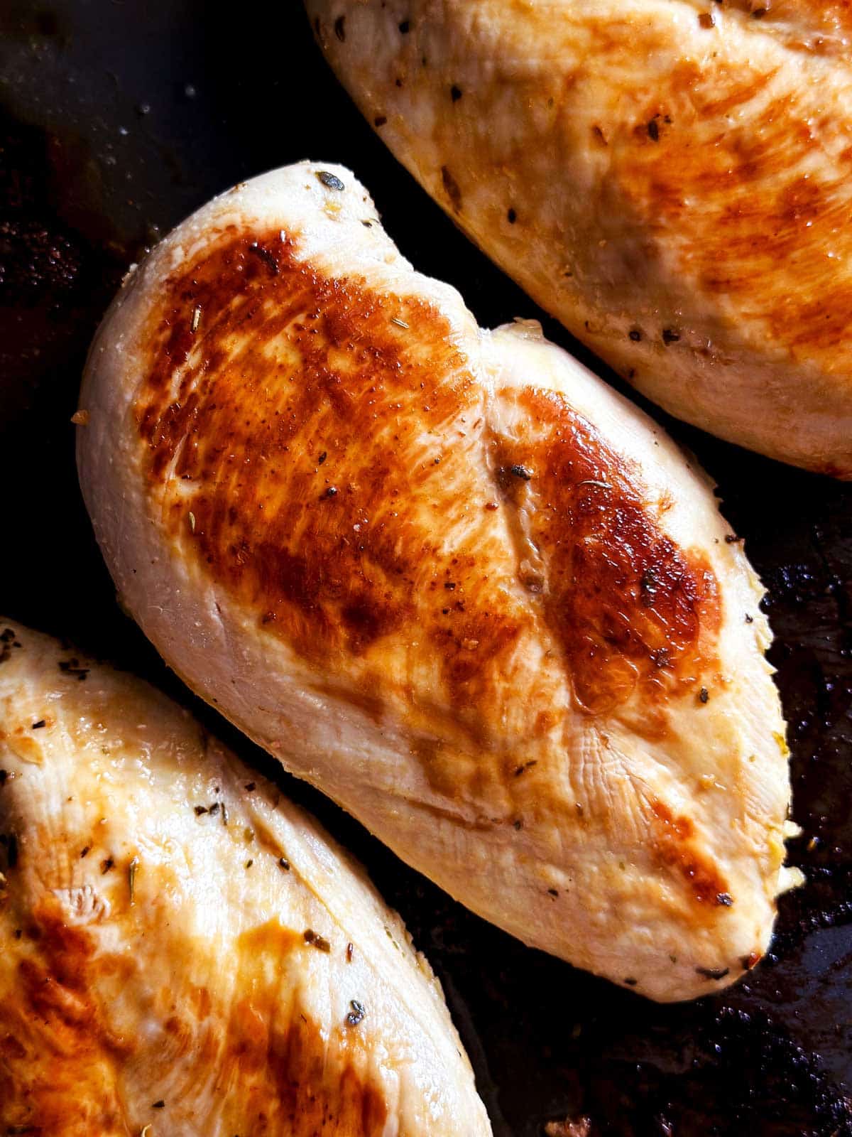 overhead view of cooked chicken breast on grilling plate