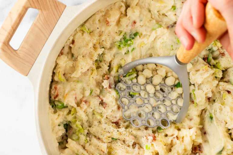 overhead view of potato masher in colcannon