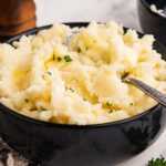 frontal view of mashed potatoes in black bowl