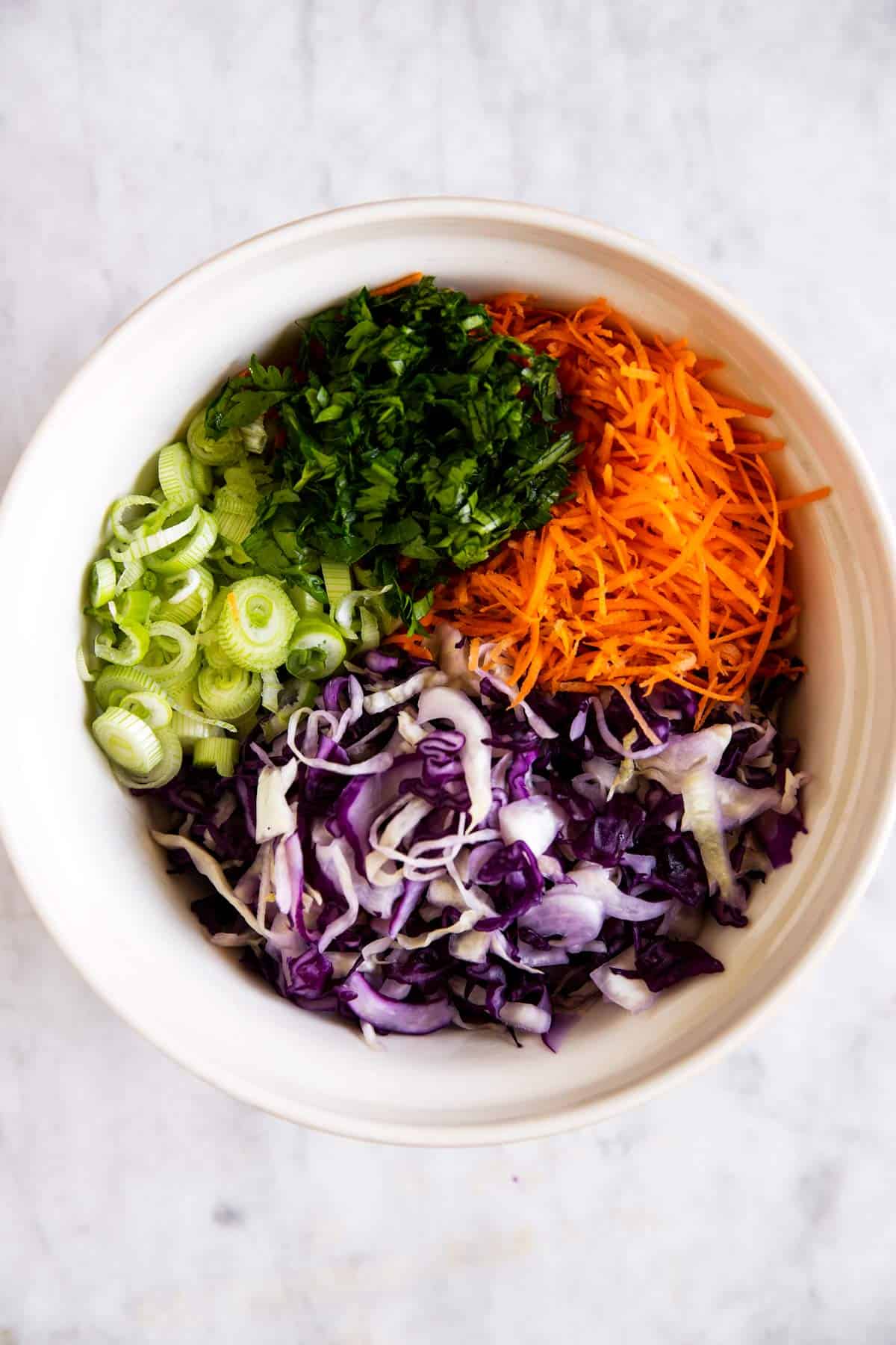 salad ingredients for cilantro lime slaw in salad bowl