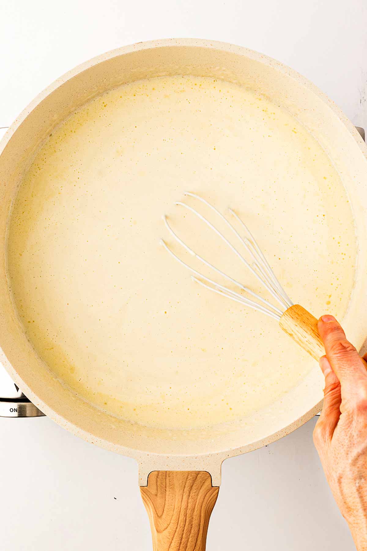 overhead view of smooth béchamel sauce in skillet