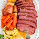 Sliced corned beef with cabbage, carrots, and potatoes on a serving platter