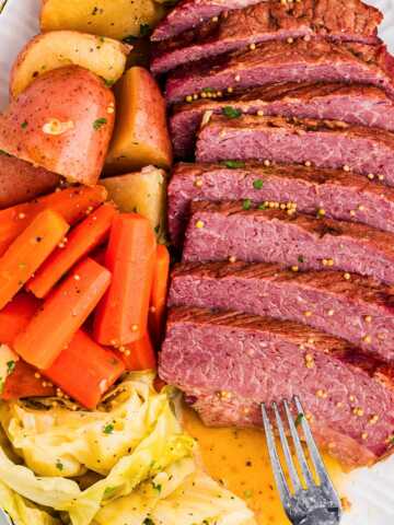 Sliced corned beef with cabbage, carrots, and potatoes on a serving platter