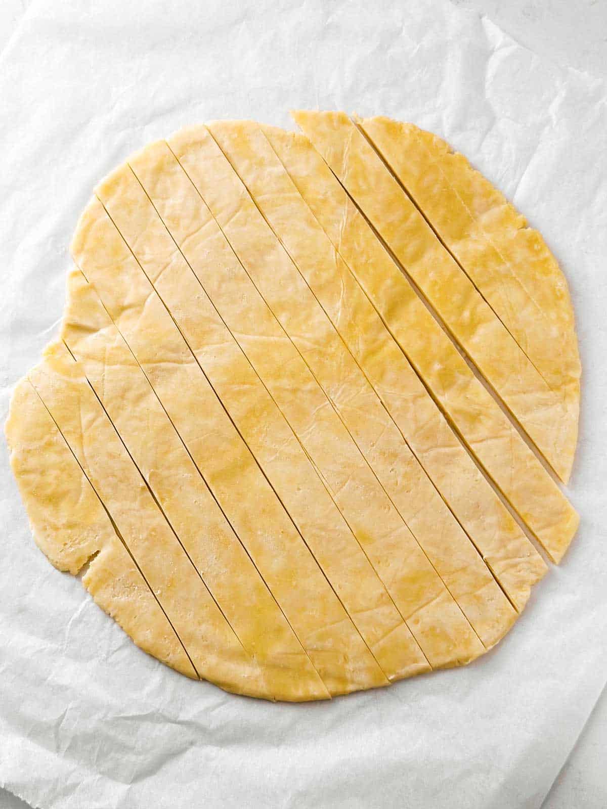 overhead view of rolled out pie crust cut into strips