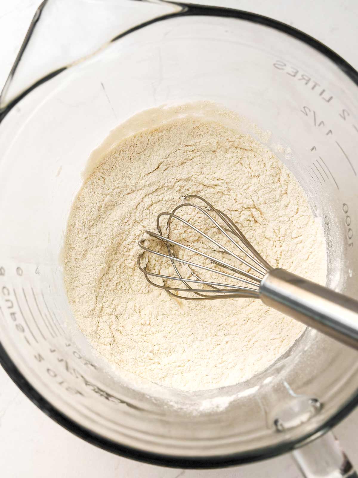whisk in glass bowl with flour mix