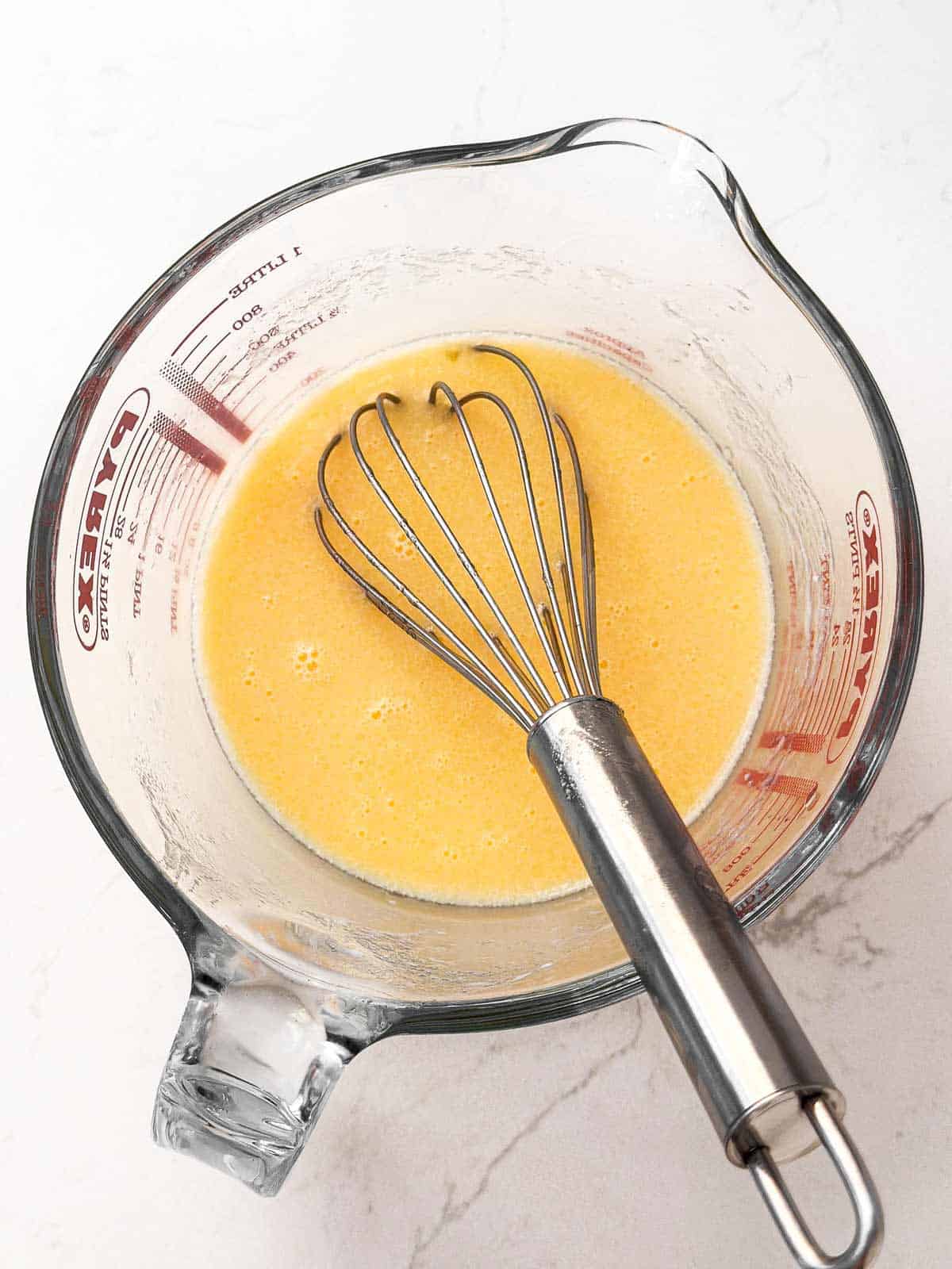 whisk in measuring jug filled with egg mixture