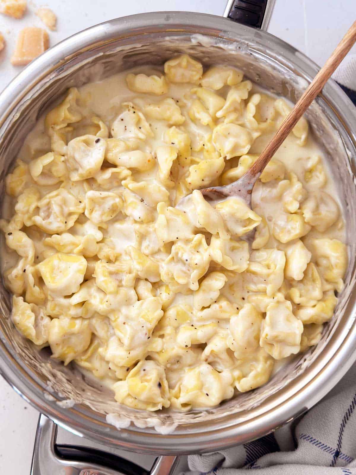 overhead view of creamy garlic parmesan cheese tortellini in skillet