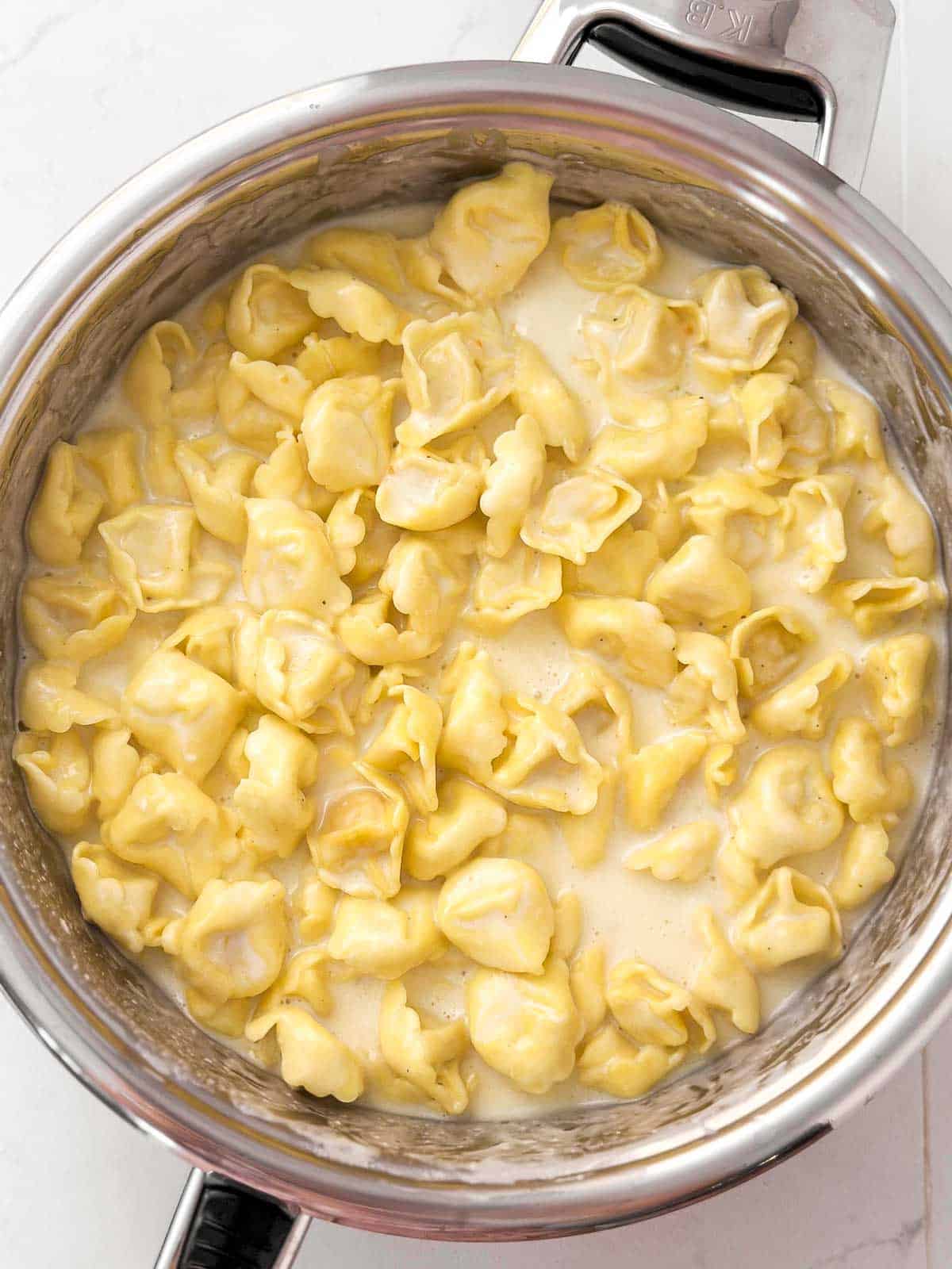 overhead view of garlic parmesan creamy cheese tortellini in skillet