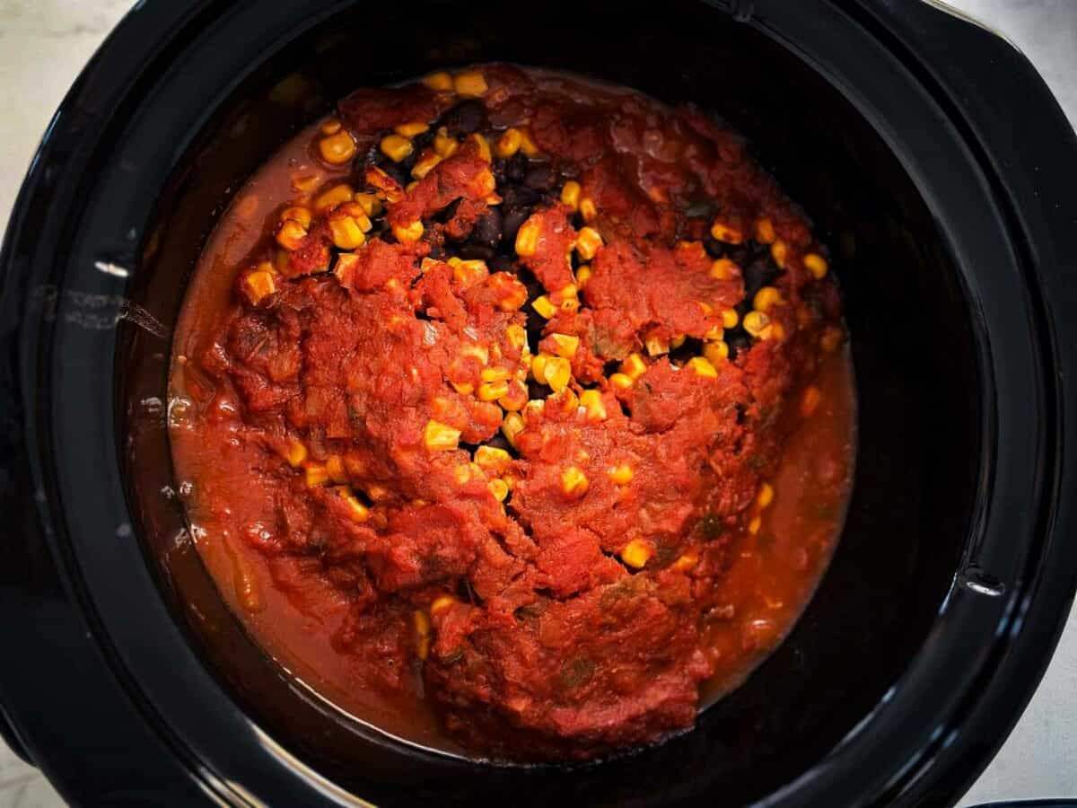 overhead view of cooked salsa, beans, corn and chicken in crock pot