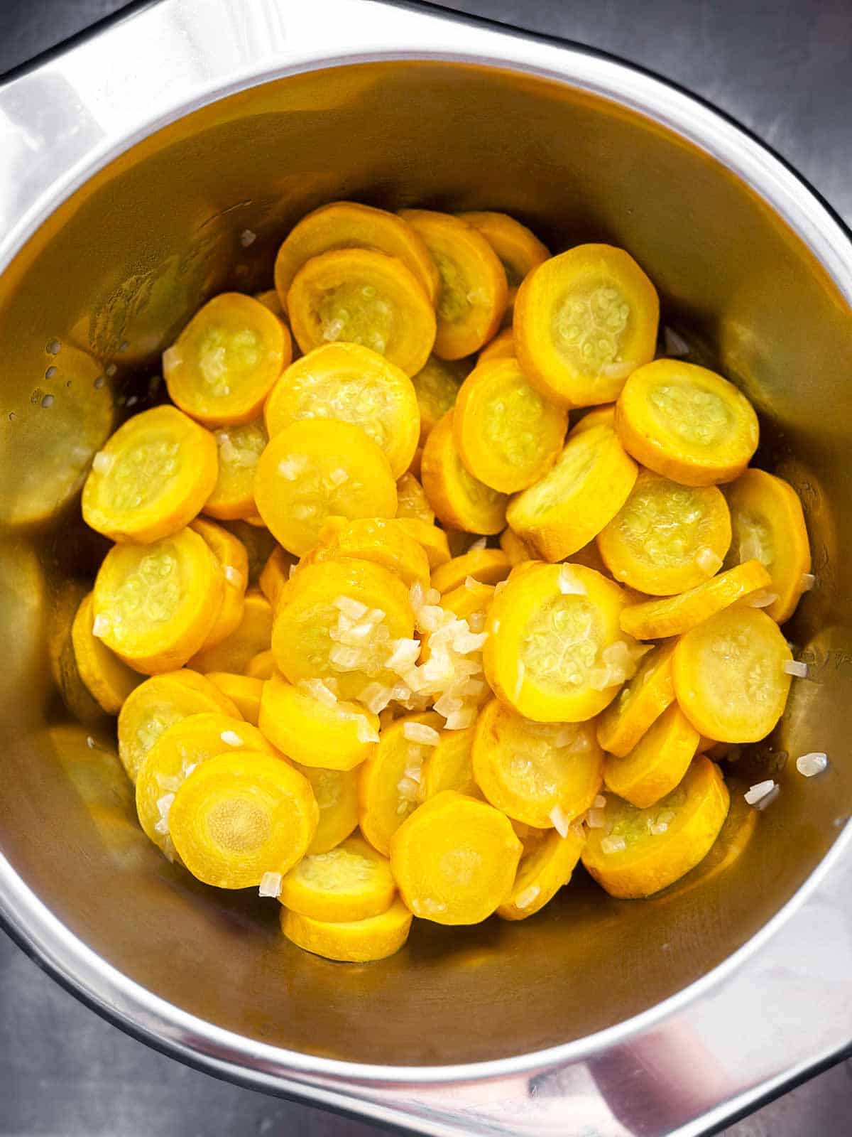 overhead view of cooked squash and onion draining in colander