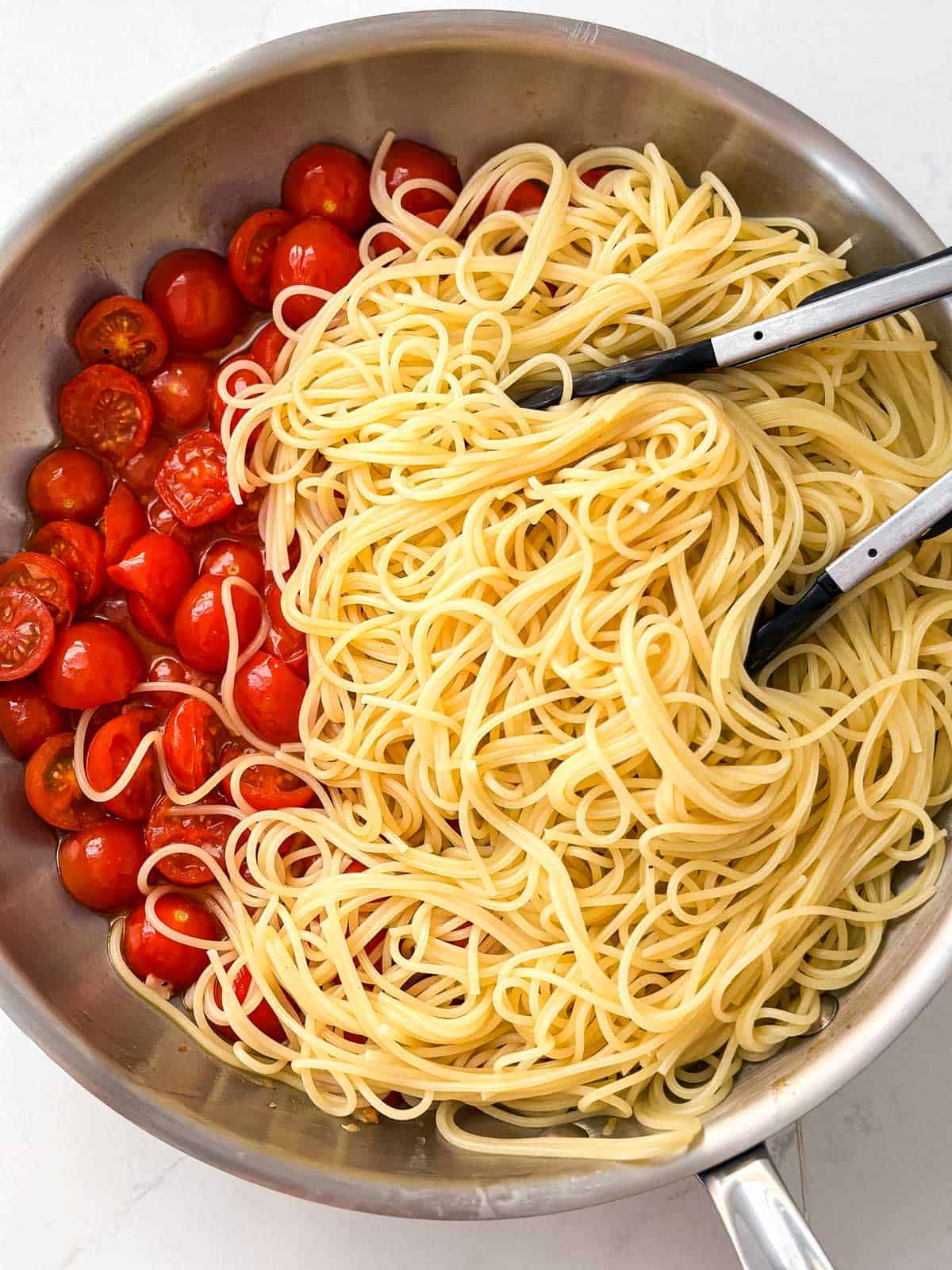 overhead view of spaghettini and tomatoes in skillet