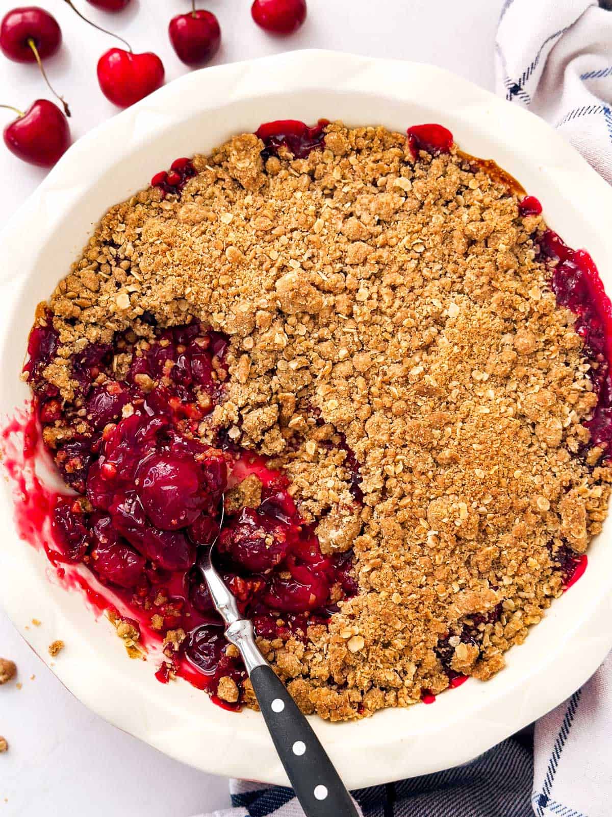 overhead view of cherry crisp with spoonful taken out