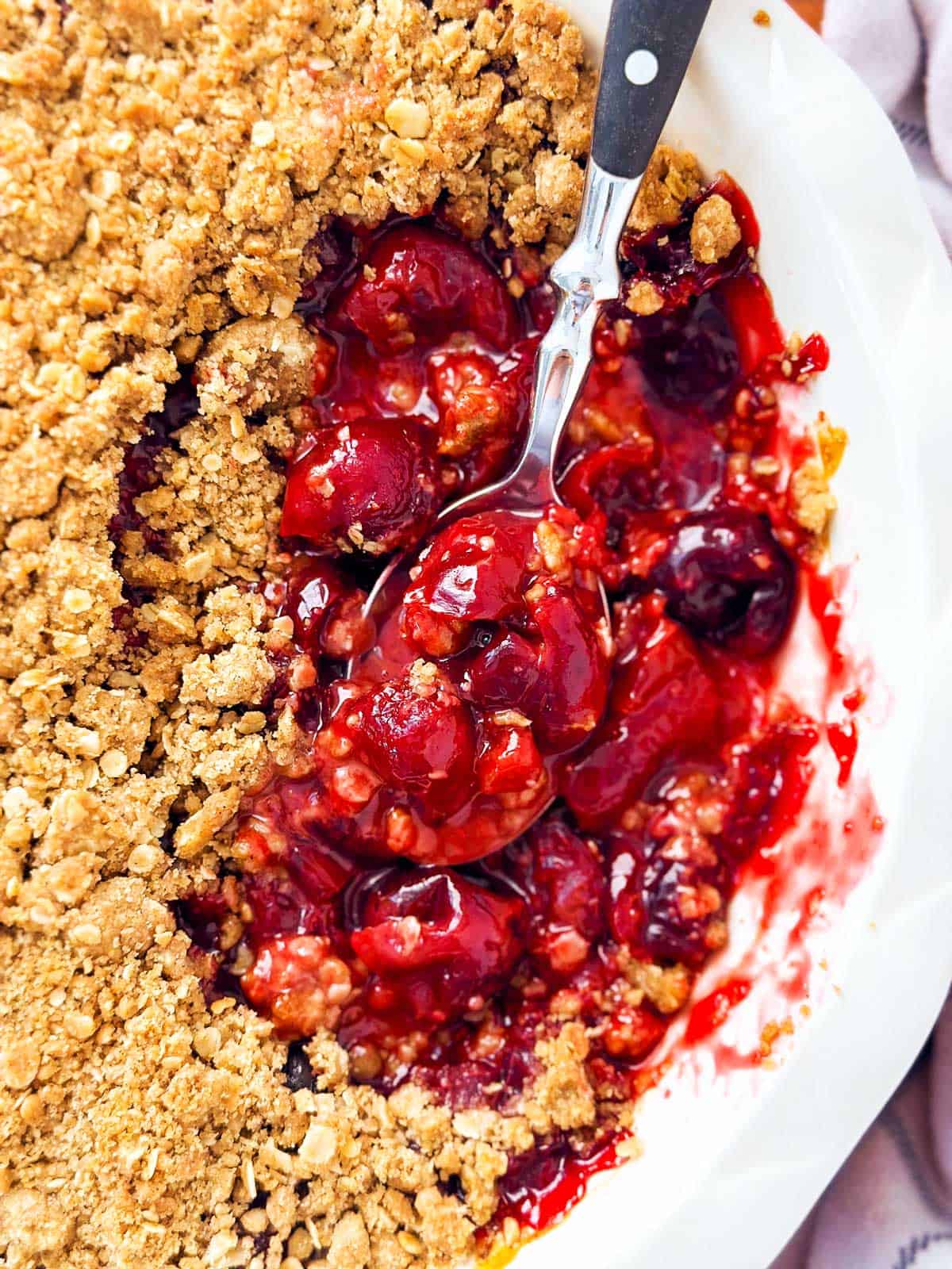 overhead close up view of spoon stuck in cherry crisp