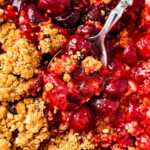 overhead close up view of spoons stuck in cherry crisp