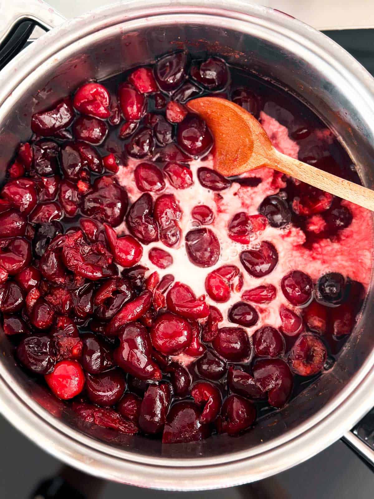 overhead view of cornstarch slurry in pan with cherry sauce