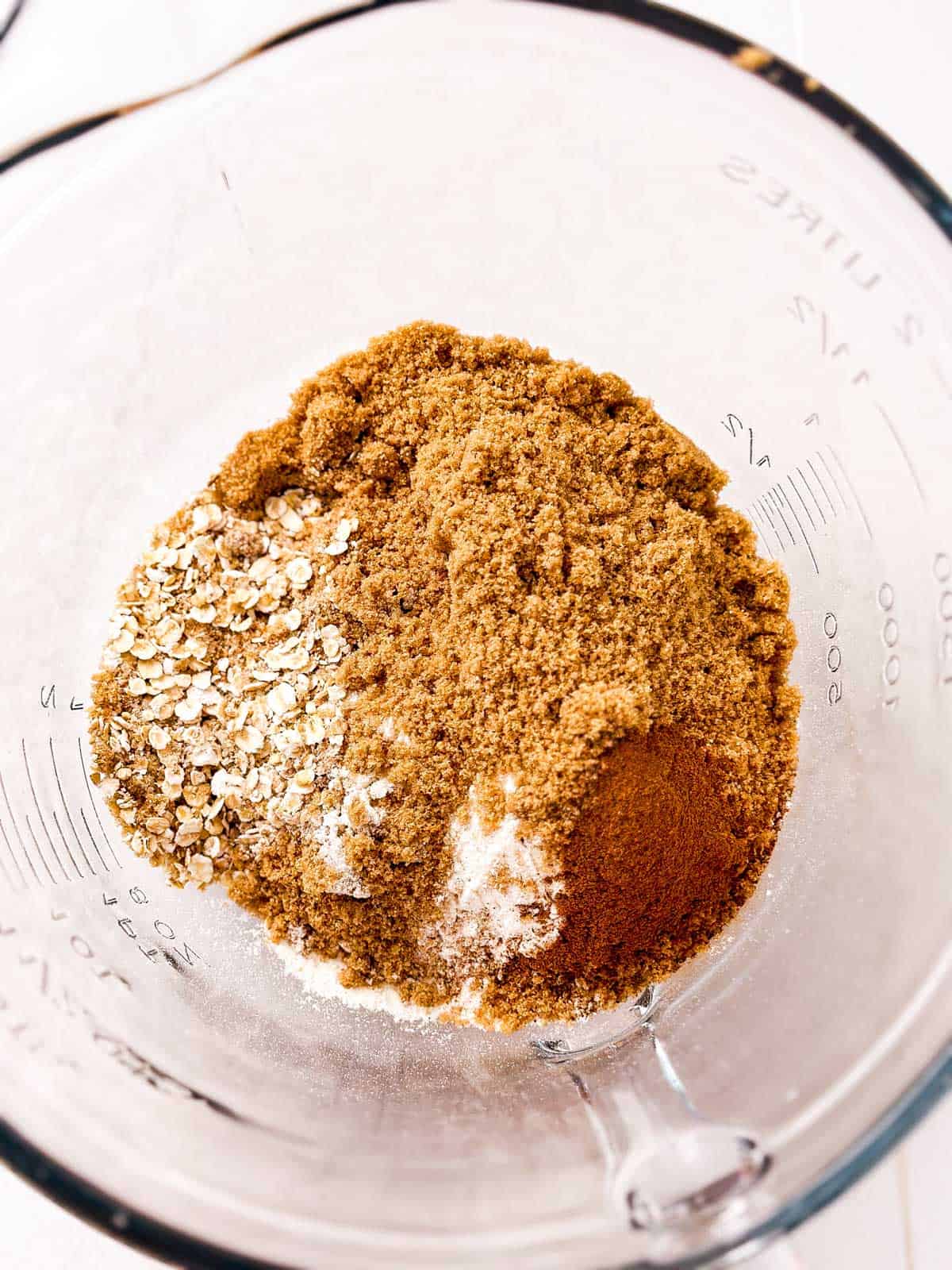 overhead view of dry ingredients for crumble topping in glass bowl