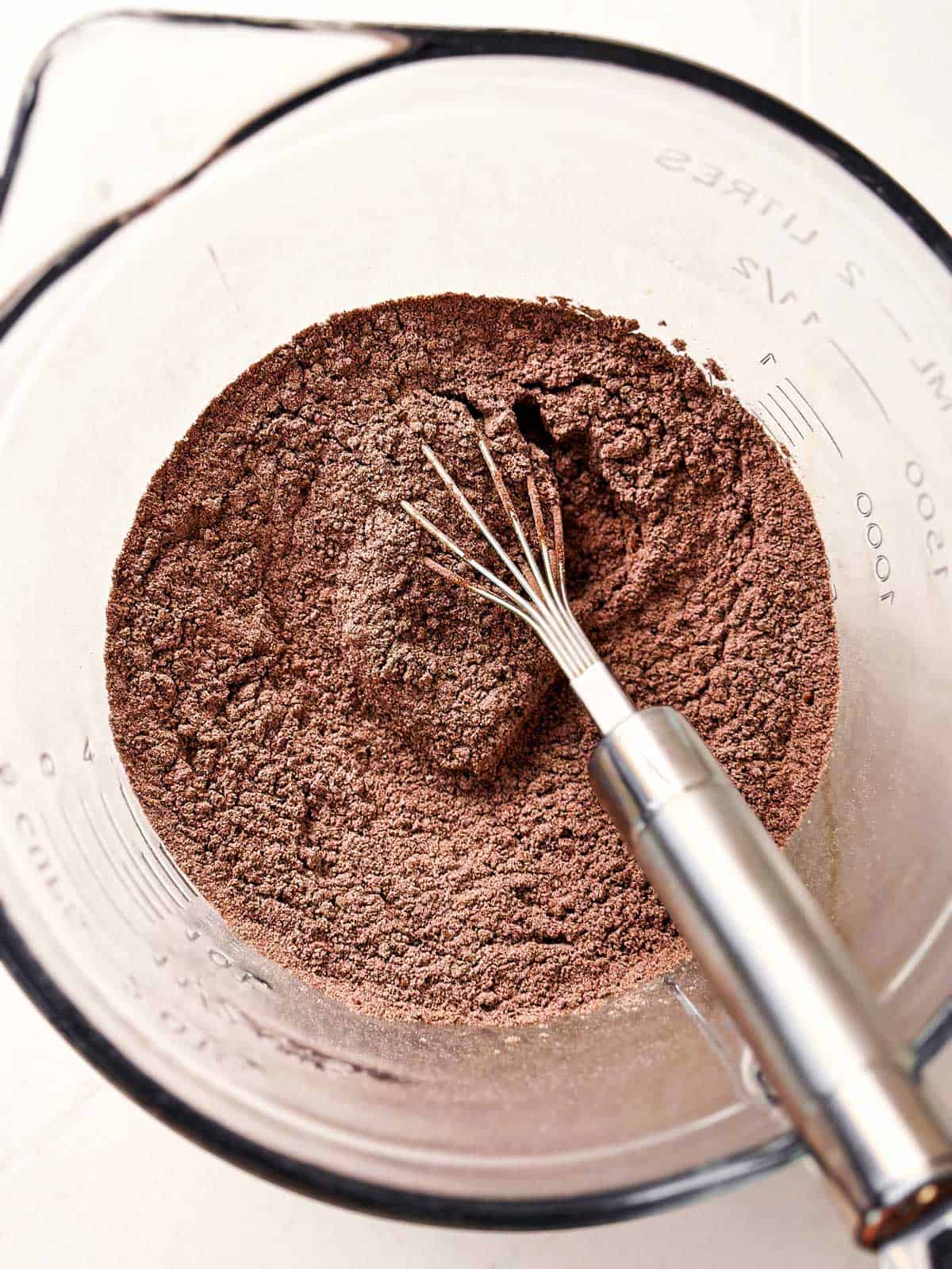 overhead view of combined dry ingredients for chocolate zucchini bread in glass mixing bowl