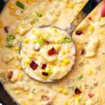 overhead close up view of ladle scooping corn chowder from Dutch oven