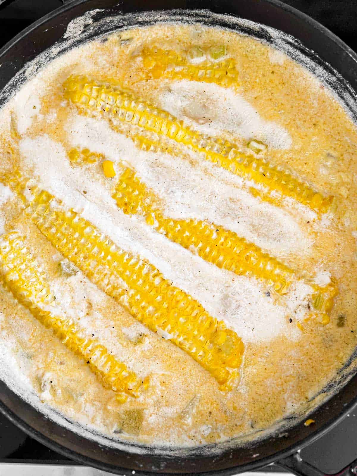 overhead view of four empty corn cobs in cooked corn chowder