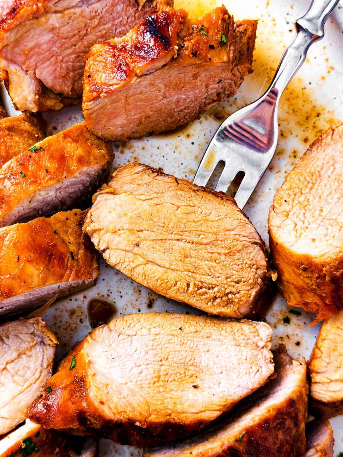 overhead close up view of grilled pork tenderloin medallion pierced with fork 